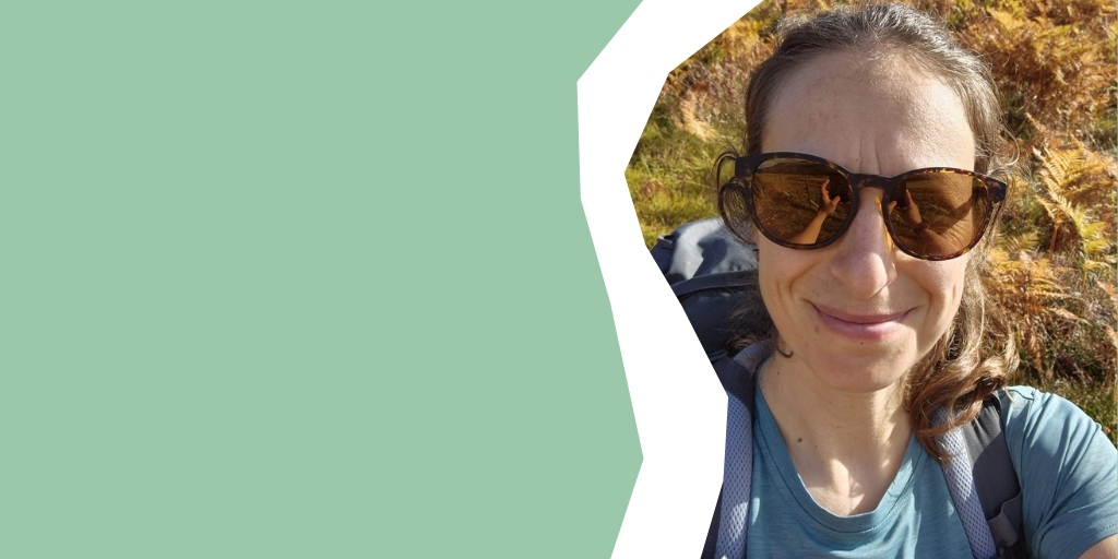 Face on selfie of Rosie, wearing sunglasses and smiling to camera