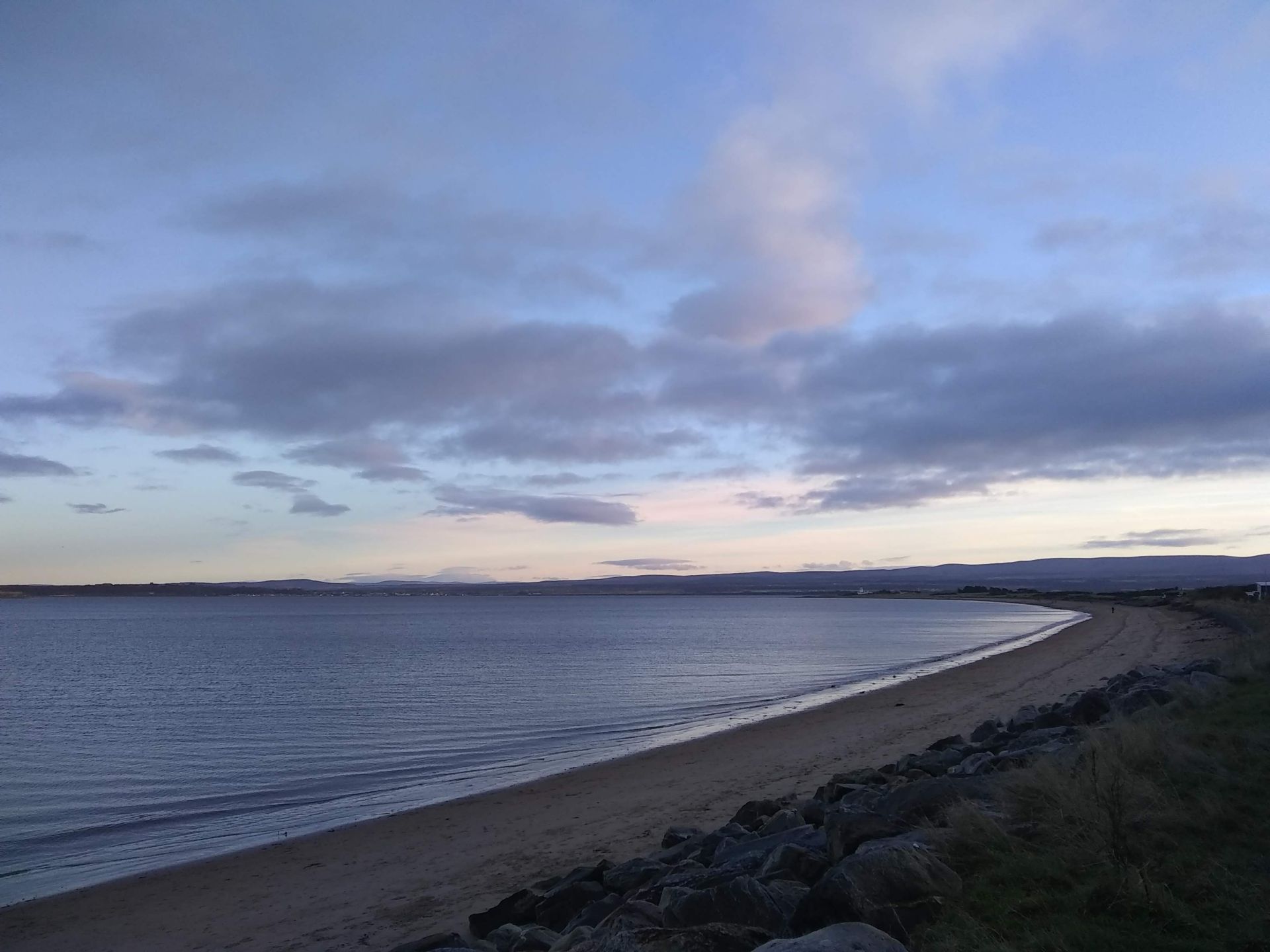 Seascape against a blue sky with scattered clouds