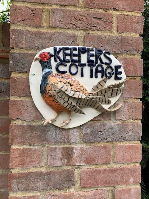 House sign for Keepers Cottage showing a sculptural heasant