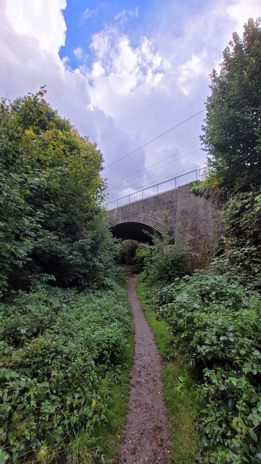 A path under a brick railway bridge