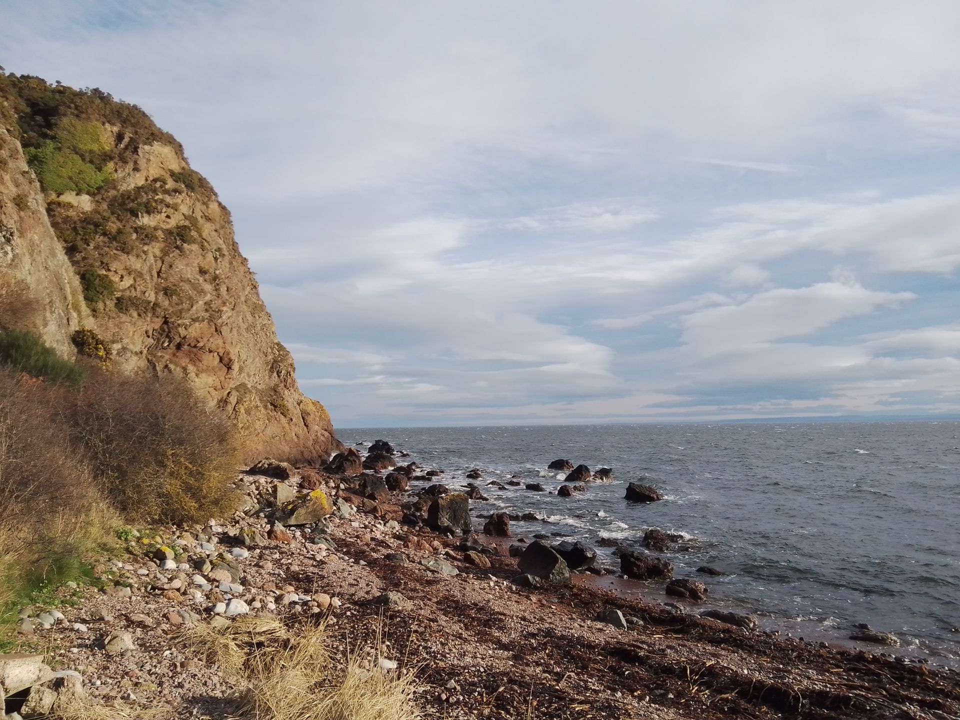 A coastal scene with calm water and rocky cliffs