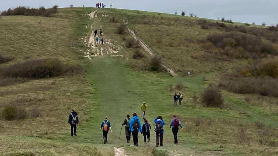 A group of hikers climbing Ivinghoe Beacon