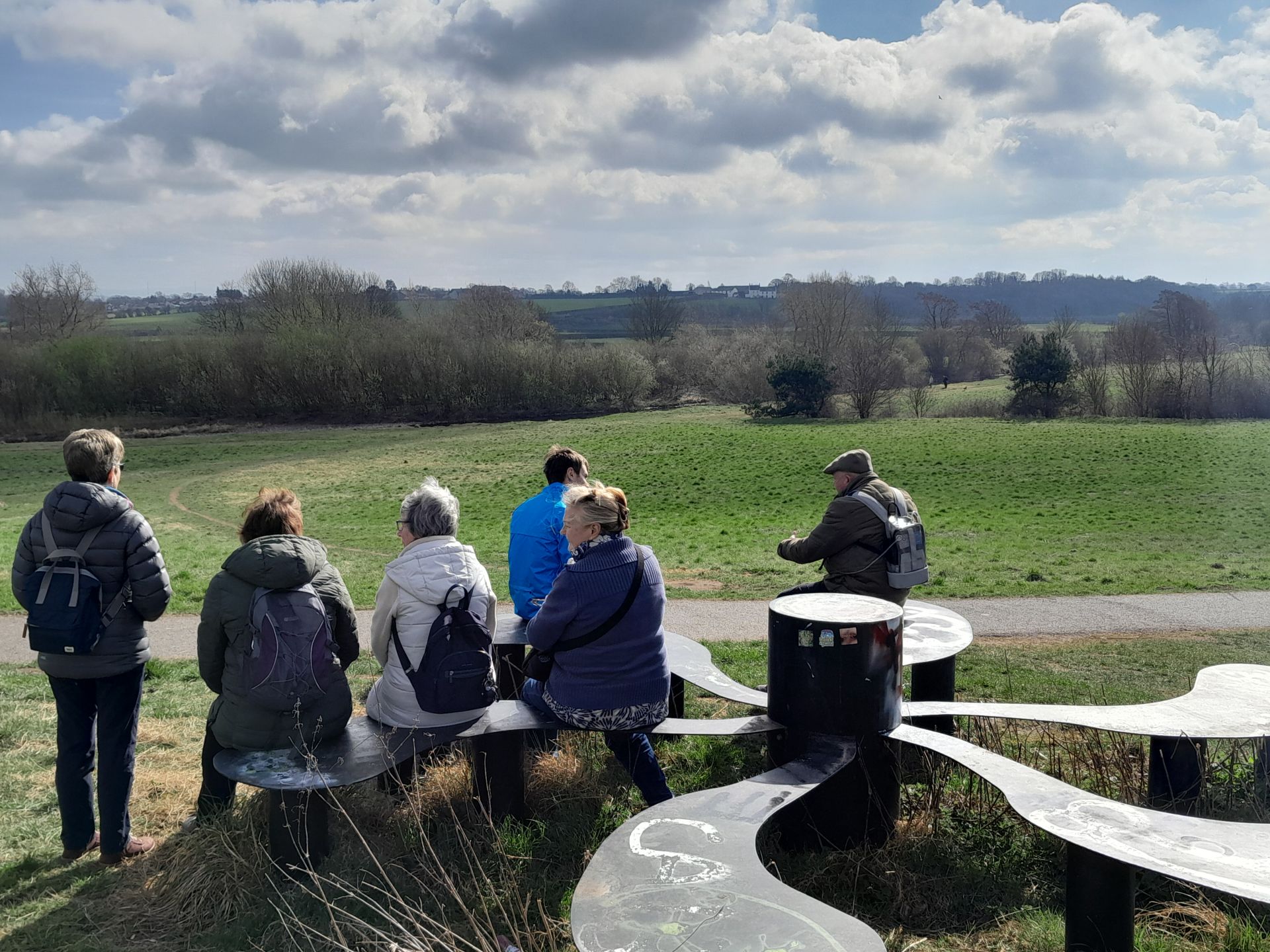 Group admiring view from bench over green space