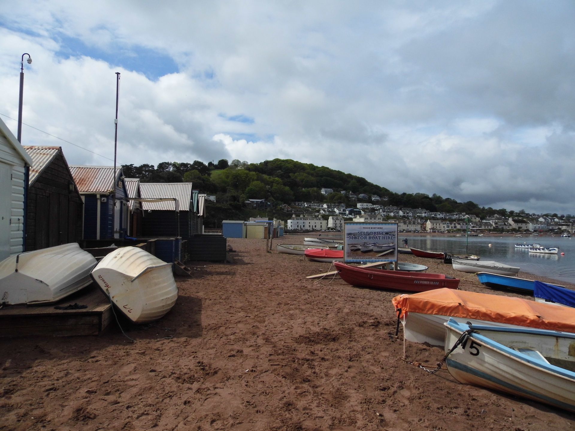 A photo of Teignmouth beach with boats resting on the sand