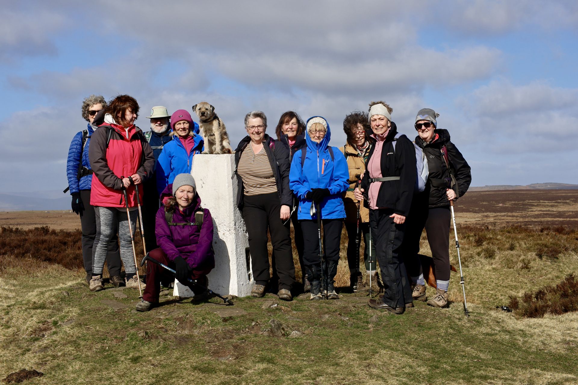group of walkers gathered round a trig point