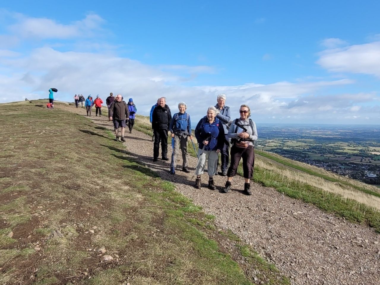 Walkers on top a hill on a bright blue day