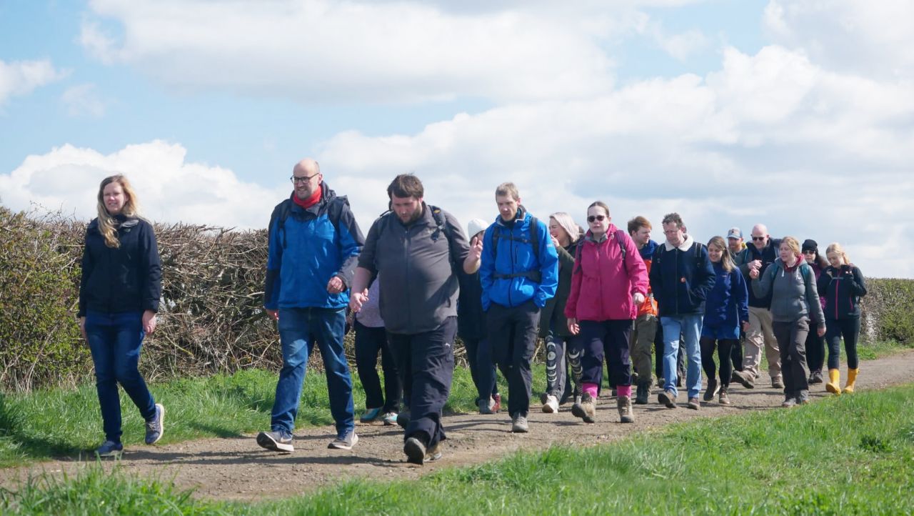 walkers by a stone wall