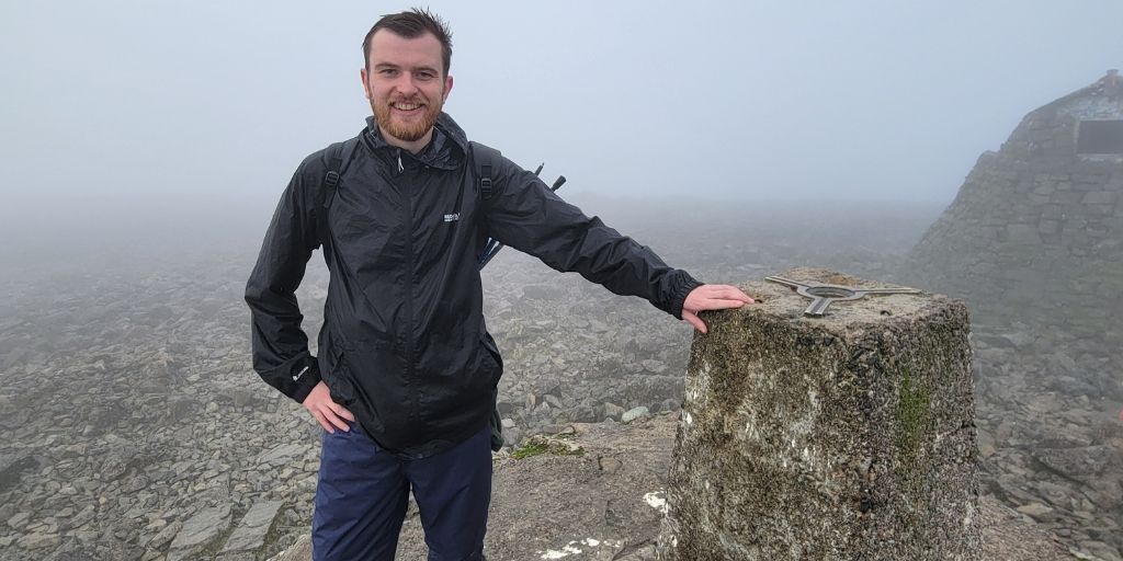 Photo of Nick at the summit of a mountain