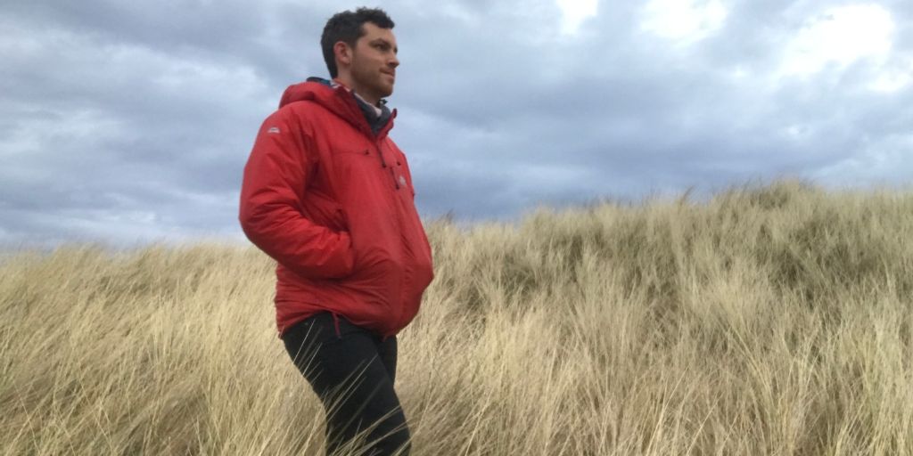 Man walking along Coul Links on a blustery day