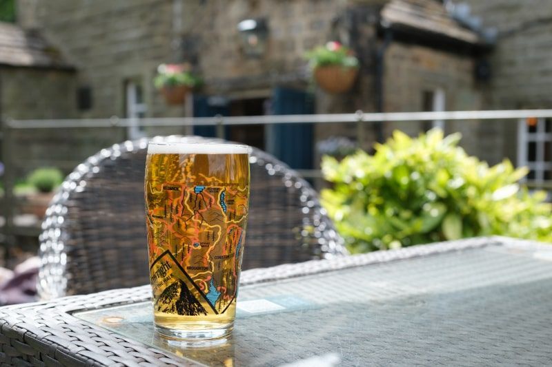A pint of beer resting on a table in a beer garden