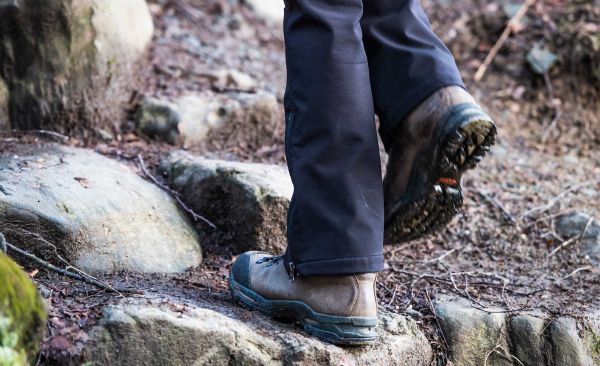 Person walking across rocky ground in boots