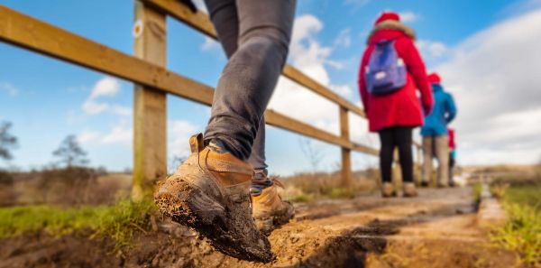 Person walking through muddy grass in boots