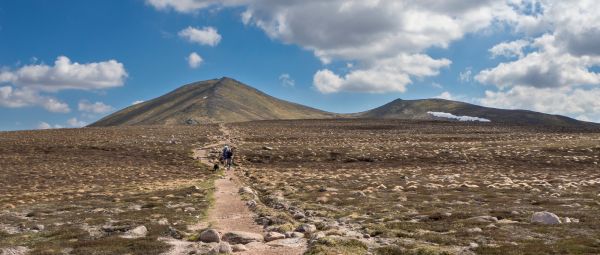 A path leading to Bynack More with a couple of people moving along it