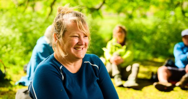 Walker sitting down in countryside smiling 