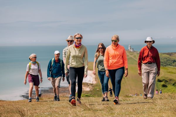 A smiling group on a sunny coastline walk