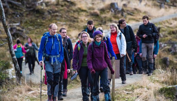 several walkers on a path all wearing jackets on a clearly brisk day