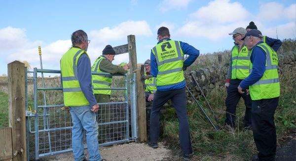 A group of volunteers fixing a path gate