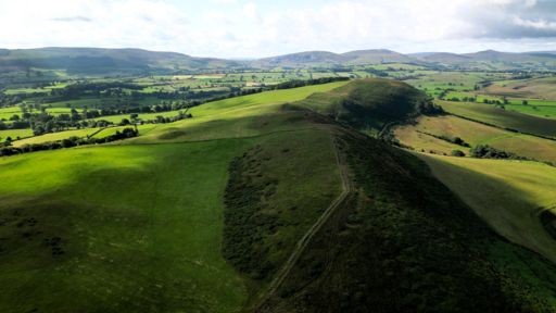 Aerial view over the green hilltop of Moel-y-Waun, in the Clwydian Hills, Wales by Llywelyn2000