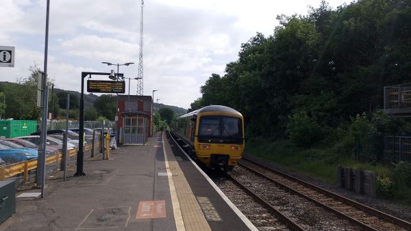 Gomshall station with a train in the platform