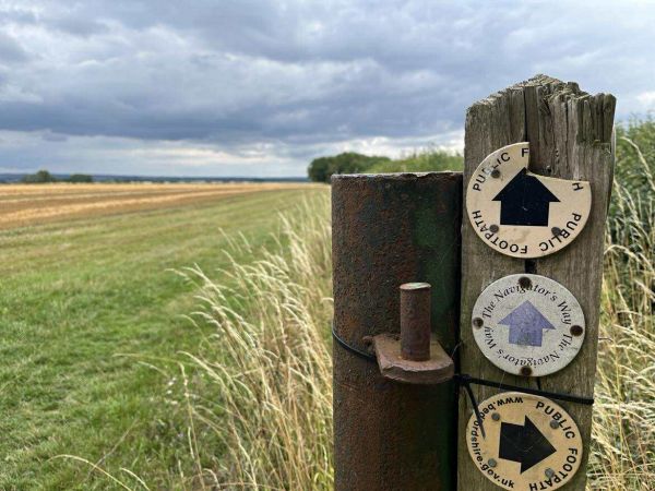 A waymark post with fields in the background