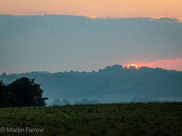 sunset and clouds over fields