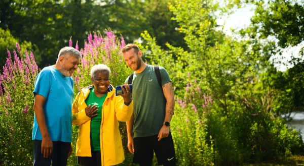 Three walkers looking for a route on a phone
