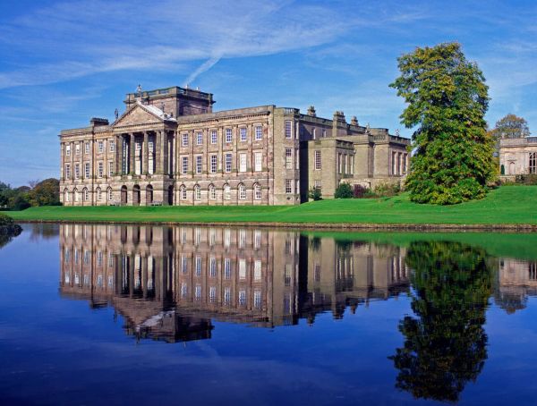 A Georgian country mansion looms over a reflective lake