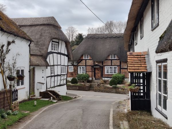 Village street with timber framed and thatched cottages.
