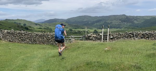 A walker approaching a stile on the Cumbrian Way