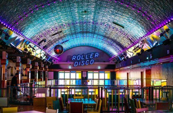 A room with mirrorball and 'Roller Disco' sign