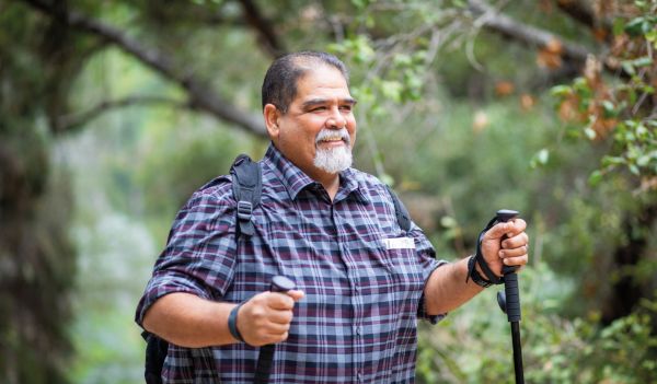 A male walker with walking poles and backpack