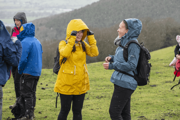 Two walkers smiling on a rainy day