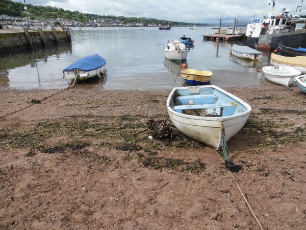 A photo of Teignmouth beach with boats resting on the sand