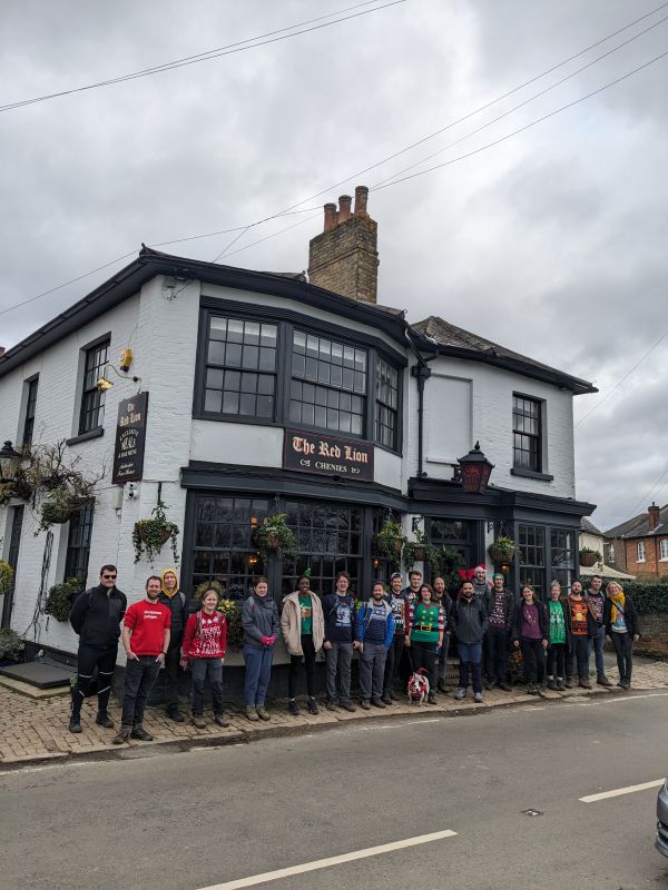 A big group in their festive jumpers stand in front of the Red Lion when we did this walk 2 years ago