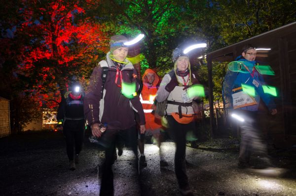 A group of people walking the Thames path at night
