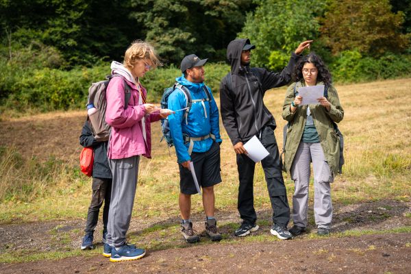 A group of young people reading a map on a walk
