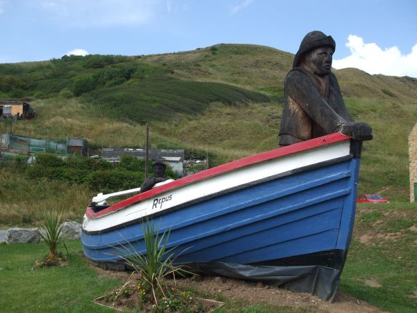 Boat with statue of a fisherman on the grass