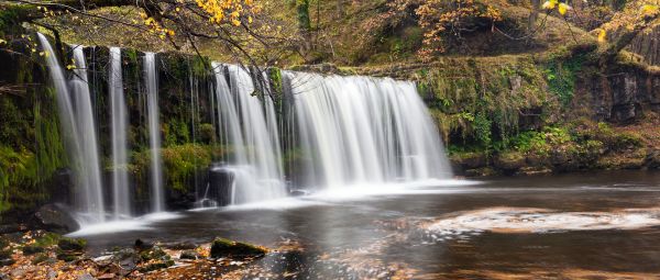 Autumn leaves at Sgwd Ddwli Uchaf, or Upper Gushing falls. Found on the Nedd Fechan, a river that flows through the Brecon Beacons National Park