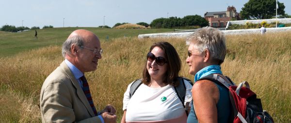 A man speaking with two women outdoors