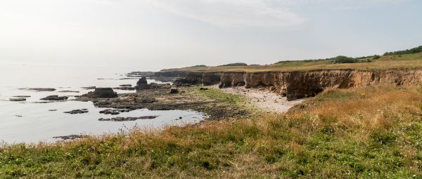 A view along small grassy cliffs above the sea