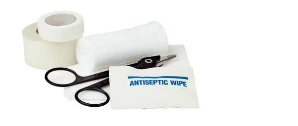 White gauze bandage roll and pad with antiseptic wipe, medical scissors and medical tape