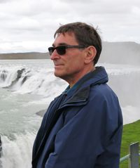 A man standing in front of a waterfall