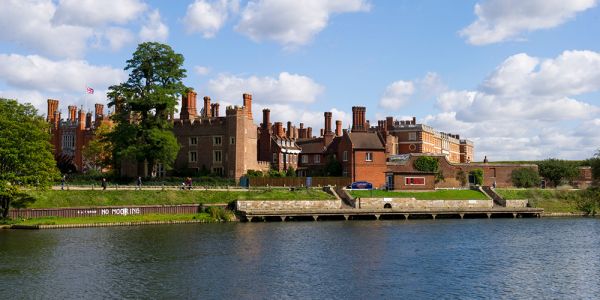 The red brick of Hampton Court Palace stands on the far bank of the river