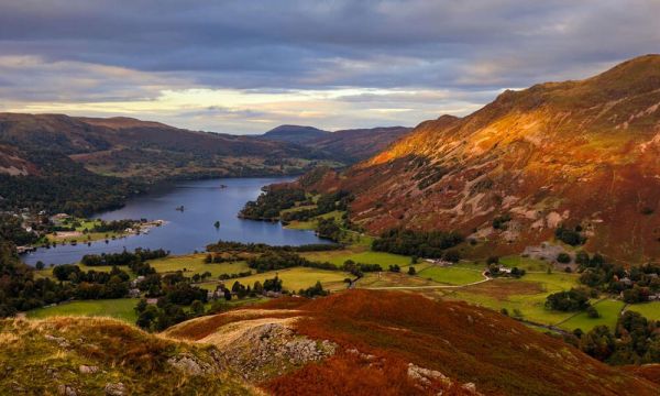 Sunset upon red heather hills above a lake