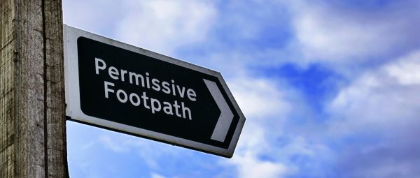 A rural footpath sign stating Permissive Path