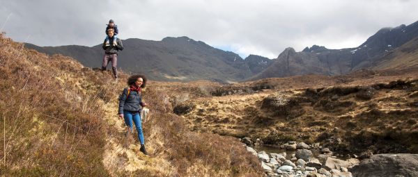 Family hiking the Fairy Pools on the Isle of Skye in the Hebrides, Scotland