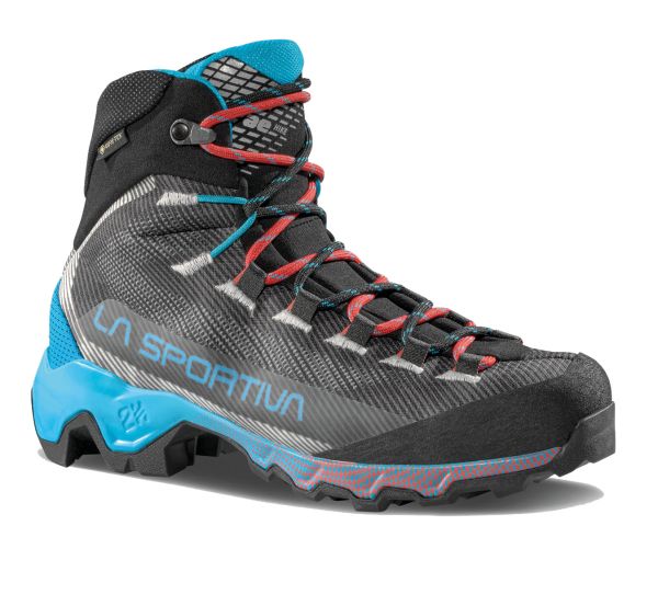 A technical mid‑cut hiking boot with a black and grey mesh upper, bright blue heel and midsole accents, and red‑and‑blue laces. The boot features protective toe reinforcement, aggressive outsole lugs, and ‘La Sportiva’ branding in light blue on the side.