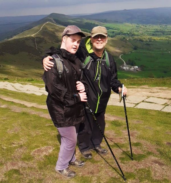 A man and young man posing on top of a hill