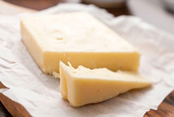 A wedge of cheese on a board