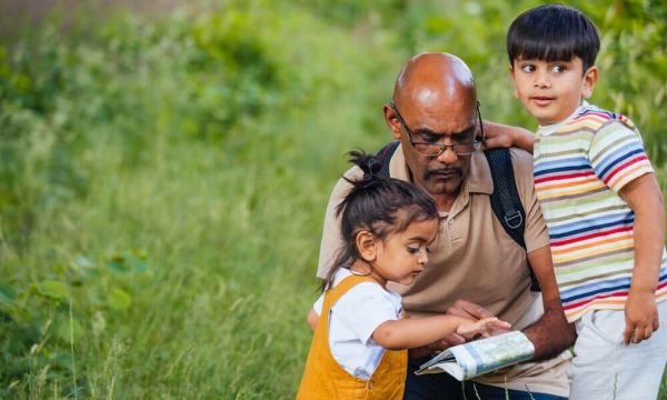 A man and who children referring to a map